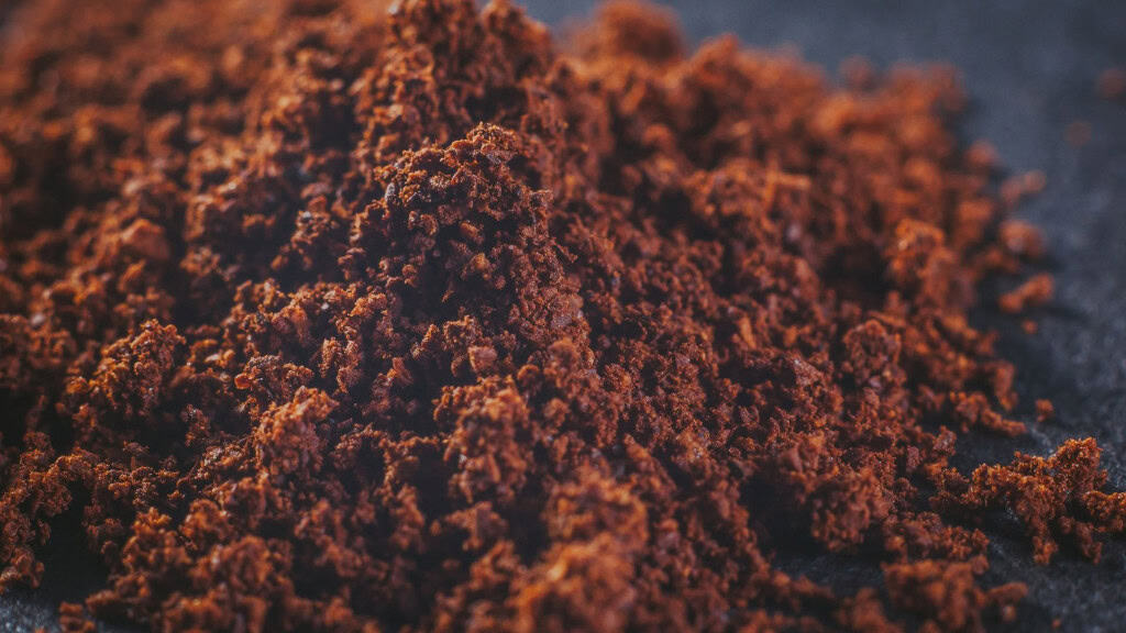 Café moído natural real com partículas em pó em um fundo escuro