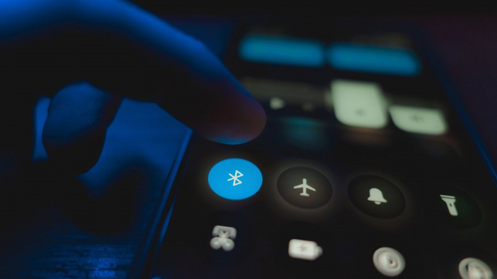 Pessoa com dedo em cima de botão que ativa Bluetooth em celular