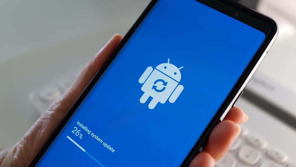 Pessoa segurando um smartphone com Android que está sendo atualizado