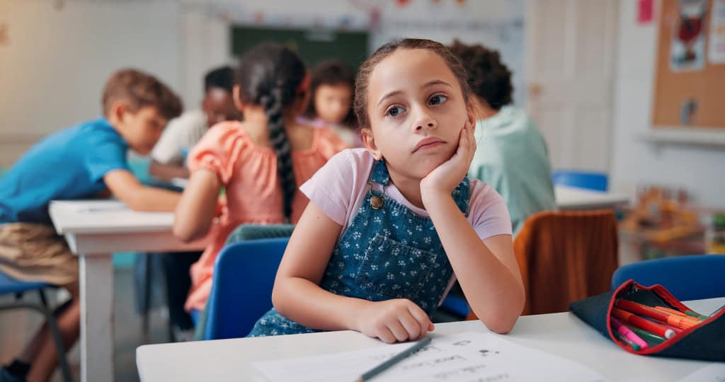 Criança entediada na sala de aula da escola