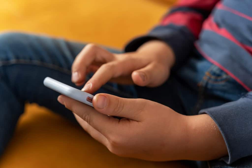 Criança com um smartphone na mão