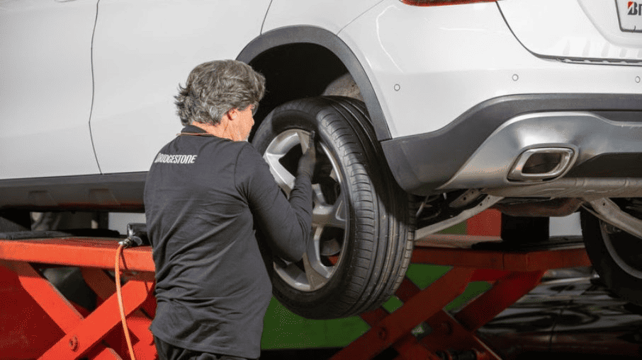 mecânico mexendo num pneu de carro