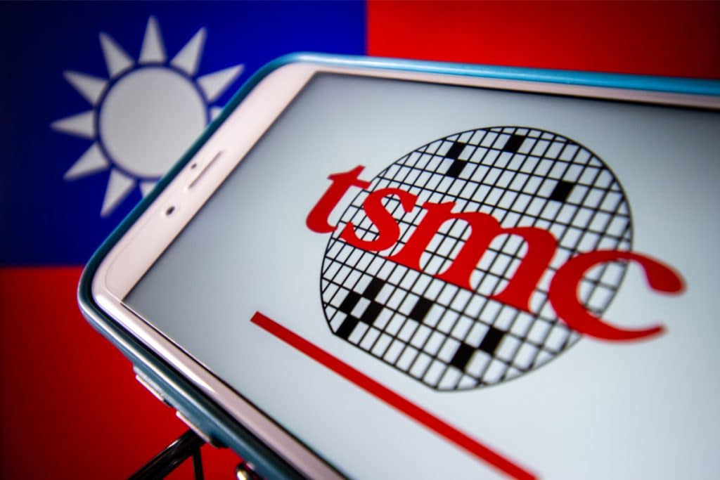 Imagem mostra a bandeira de Taiwan ao fundo, com um iPhone à frente exibindo o logotipo da TSMC. Empresa anunciou litografia de 2 nanômetros para seus processadores a partir de 2023
