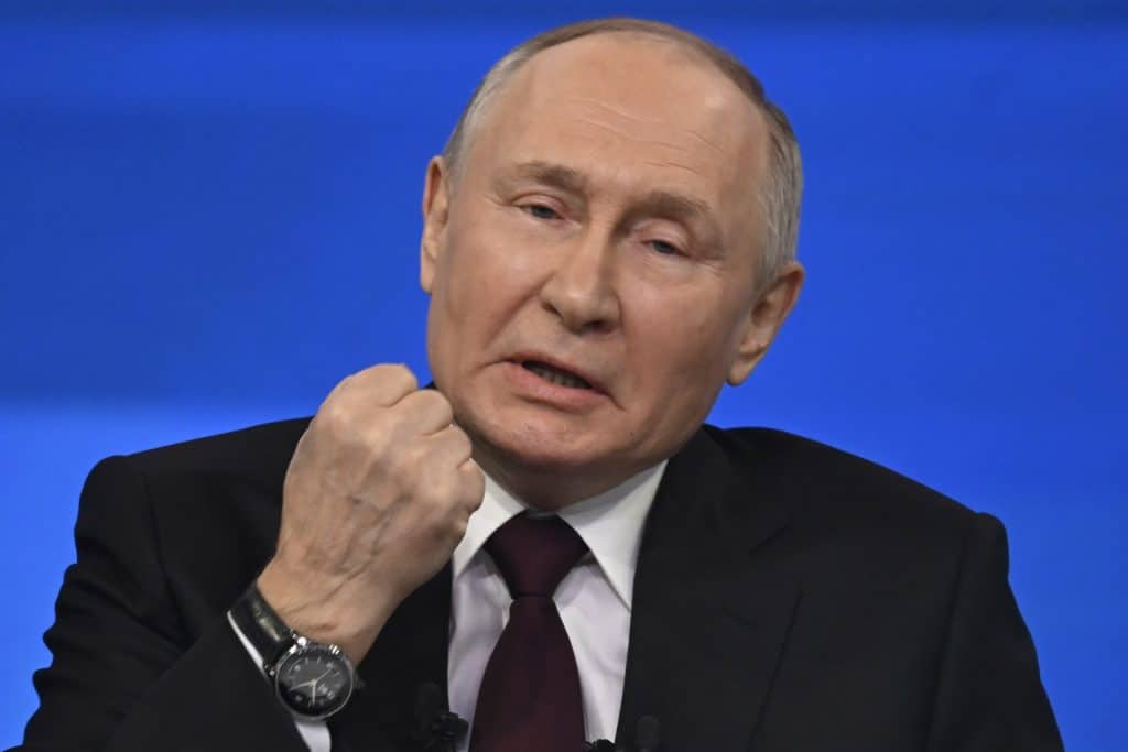 Vladimir Putin com o punho erguido próximo ao queixo