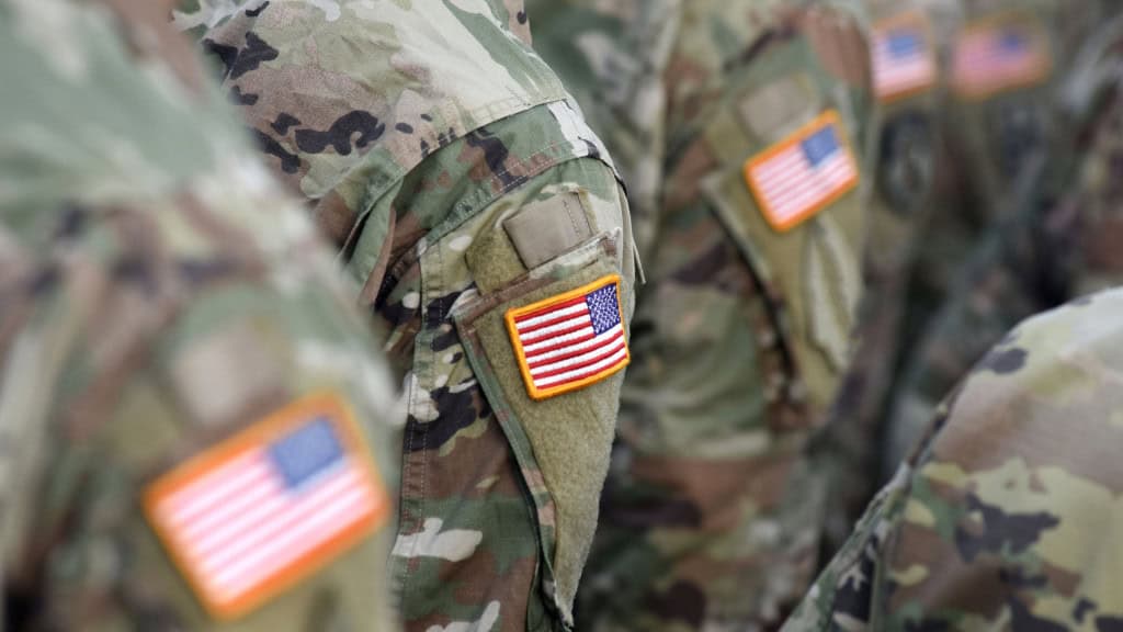 Close em miniaturas da bandeira dos EUA costuradas em uniformes de soldados do Exército