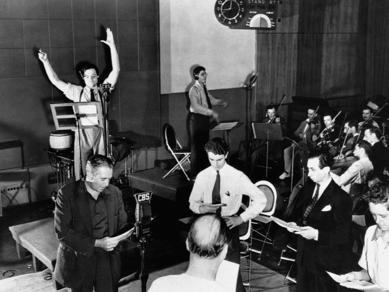 Orson Welles e a equipe de músicos e atores interpretando A Guerra dos Mundos na Rádio CBS