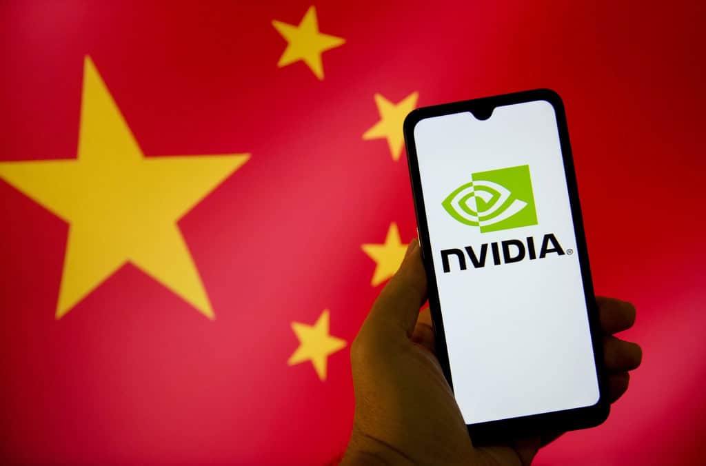 Bandeira da China ao fundo com uma mão segurando um smartphone que mostra, em sua tela, o logo da Nvidia