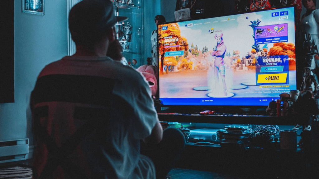 Pessoa jogando Fortnite em frente a televisão