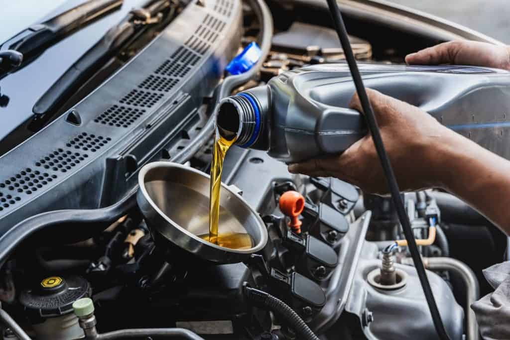 Imagem mostra óleo automotivo sendo despejado dentro de um carro