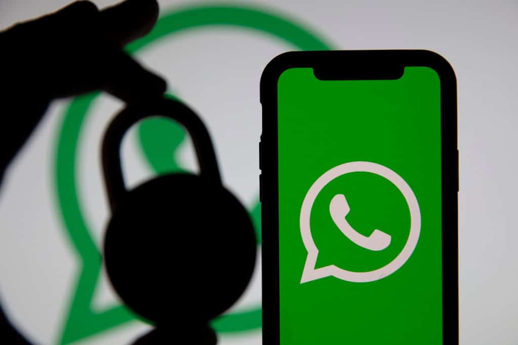 Cadeado lado de um smartphone exibindo o logo do WhatsApp